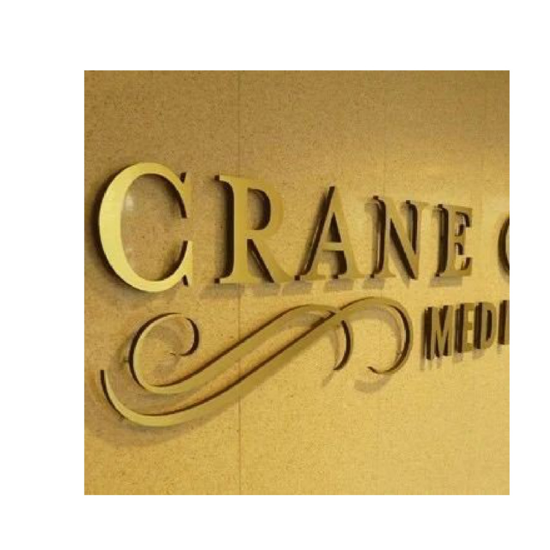 Close-up of custom 3D office signage with raised gold letters and decorative script on a wood-finish background