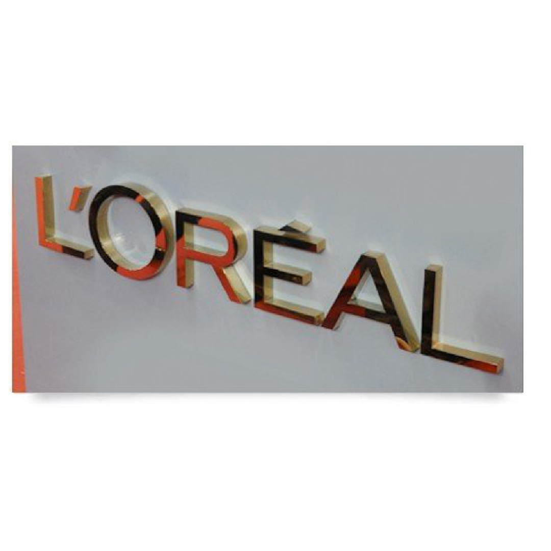 3D L'Oréal wall signage with raised metallic letters in gold, black, and red finish