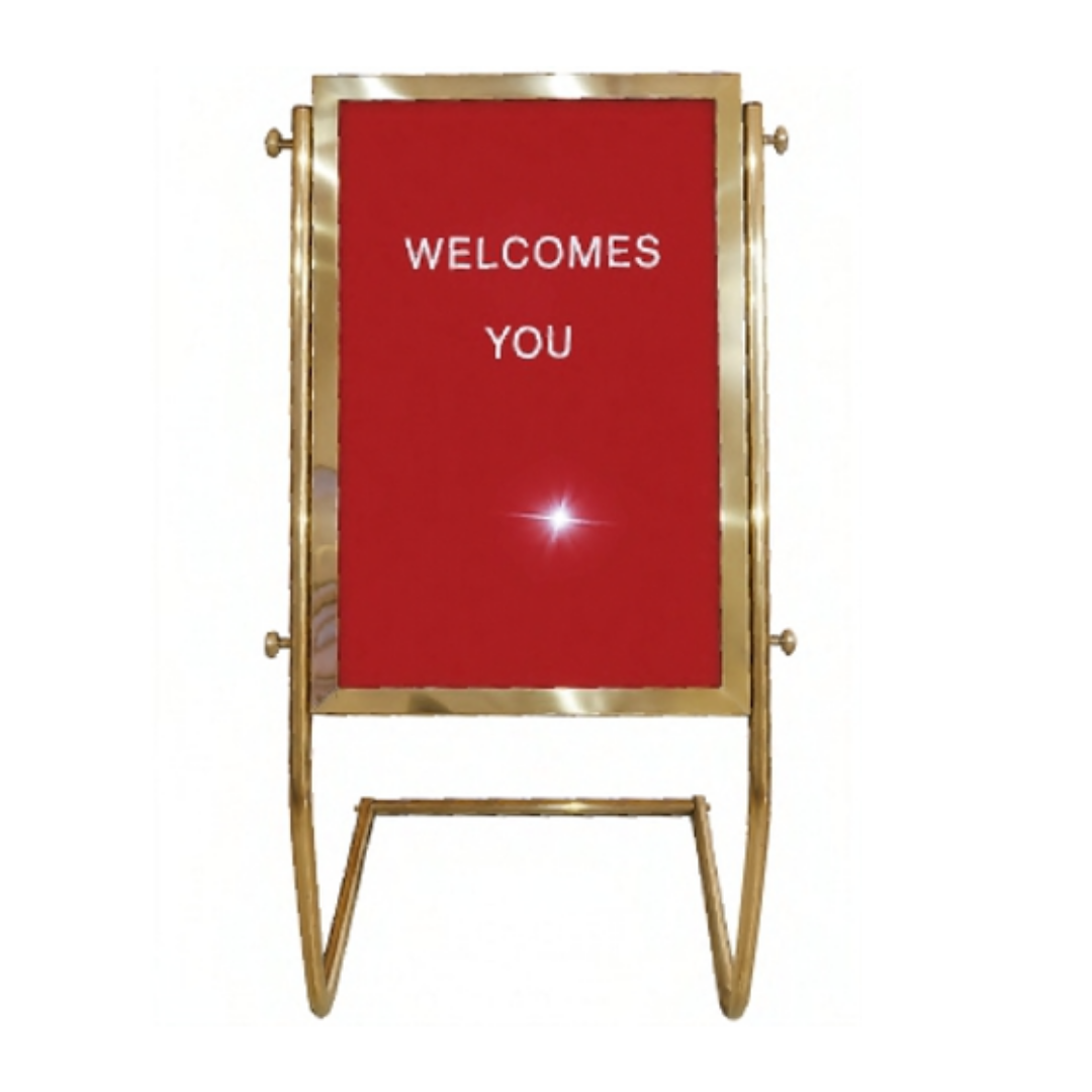 Gold-colored freestanding display stand with a red panel reading “WELCOMES YOU.”