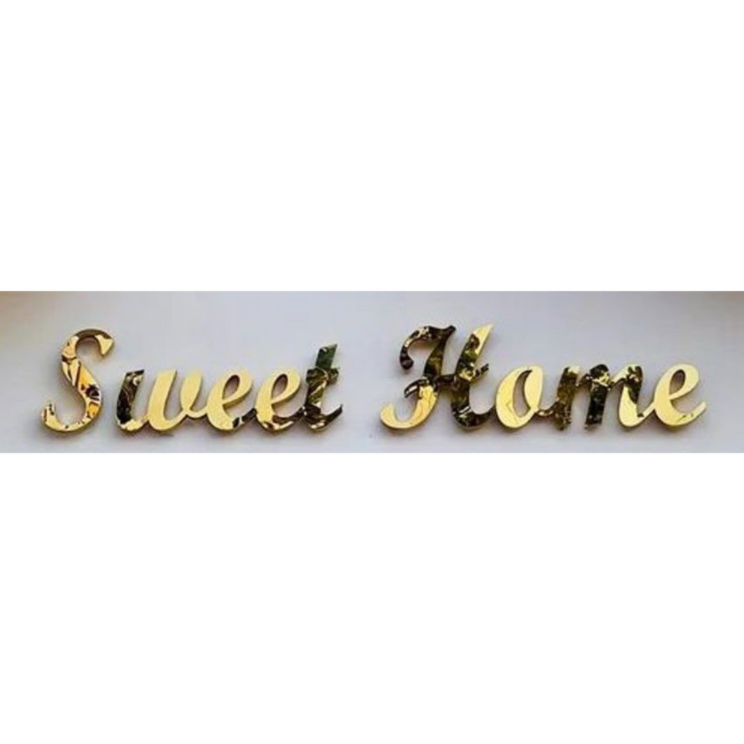 Decorative raised gold cursive lettering spelling “Sweet Home” on a light background.