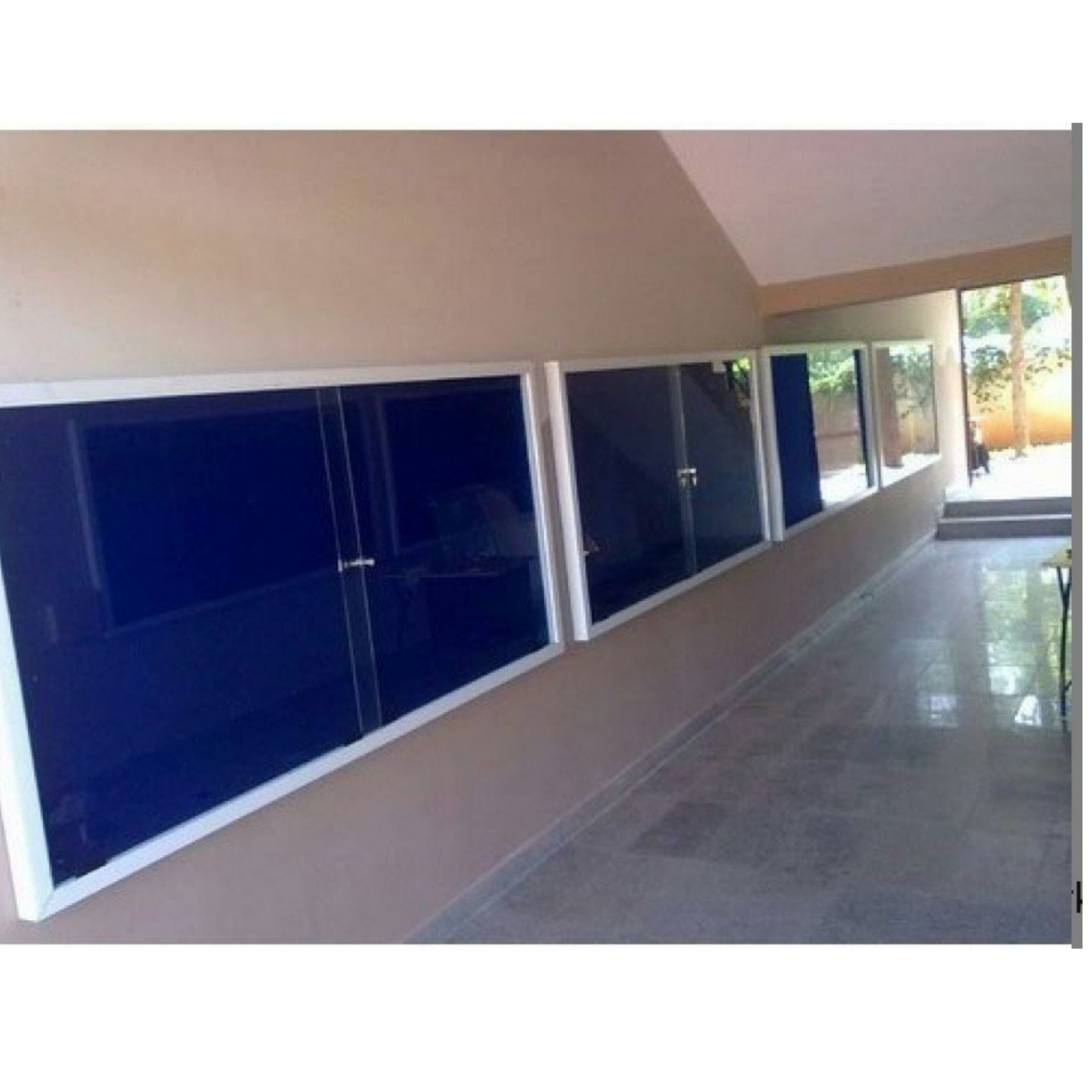 Premium wall mounted lockable notice board with sliding glass doors, blue fabric pinboard surface, and aluminum frame for securely displaying notices, announcements, and information.