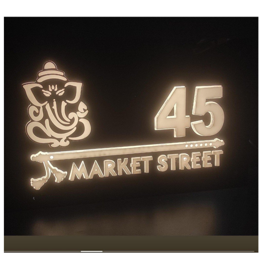 Black illuminated wall name plate featuring a Ganesha motif, house number 45, and the words “MARKET STREET”