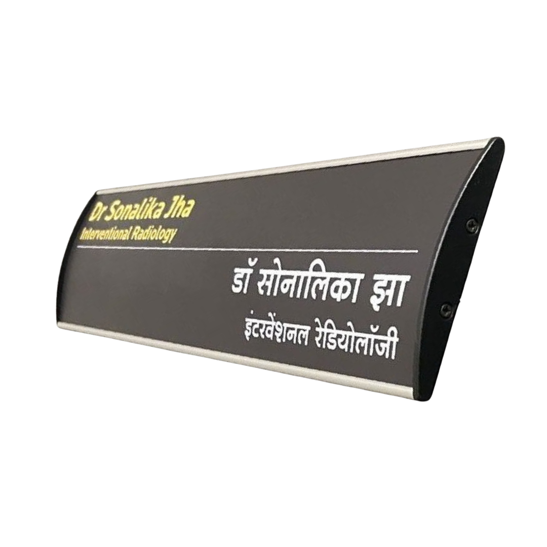 Black curved desk name plate displaying Dr. Sonalika Jha and International Radiology in English and Hindi