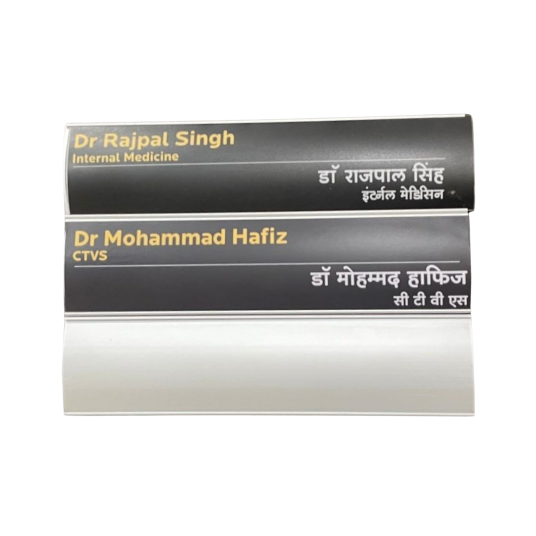 Two black curved desk name plates displaying doctors’ names and specialties in English and Hindi