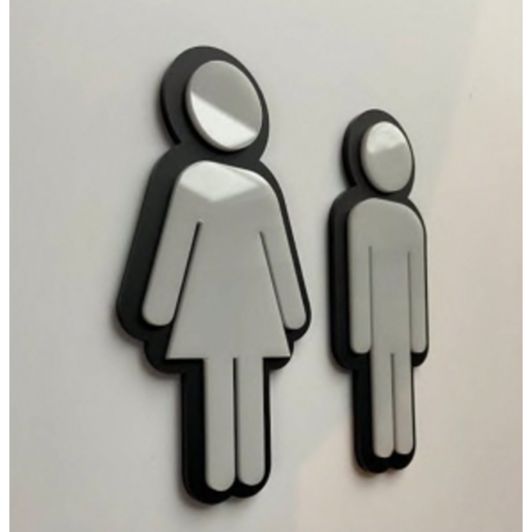 Three-dimensional black-and-white restroom icons showing a female figure on the left and a male figure on the right.