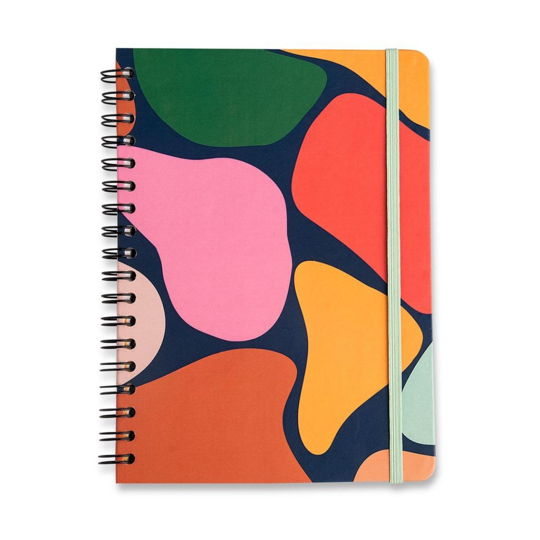 Colorful spiral notebook with abstract geometric cover design in pink, green, orange, red, and blue