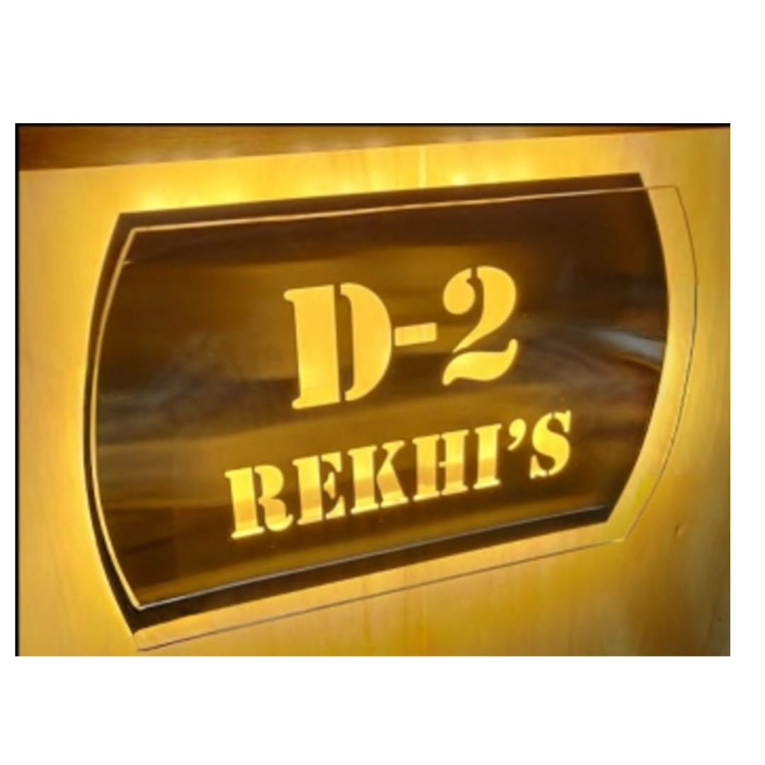 Premium dark wooden nameplate displaying “D-2” and “REKHI’S” in raised gold lettering with a decorative double border.