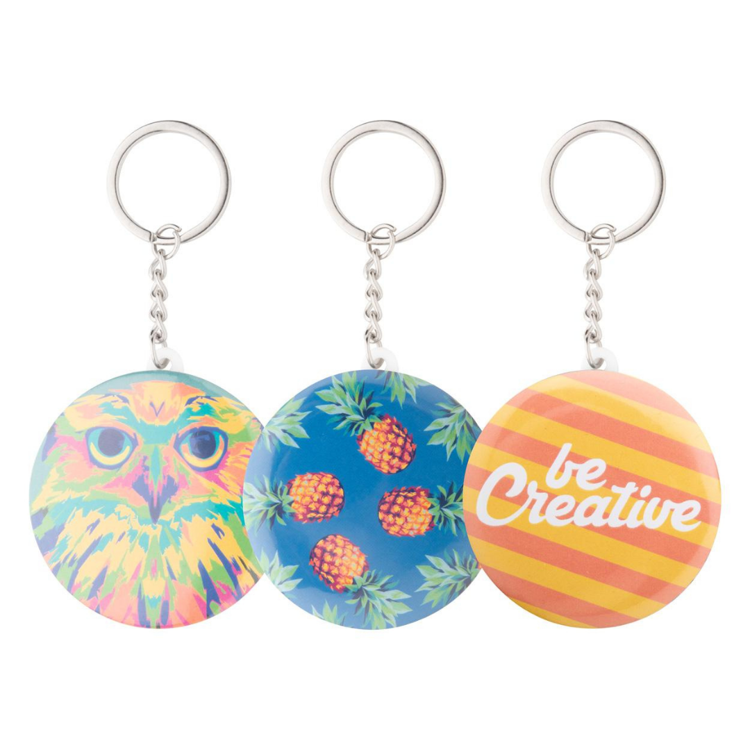 Three round custom keychains featuring an owl, pineapple pattern, and be creative design